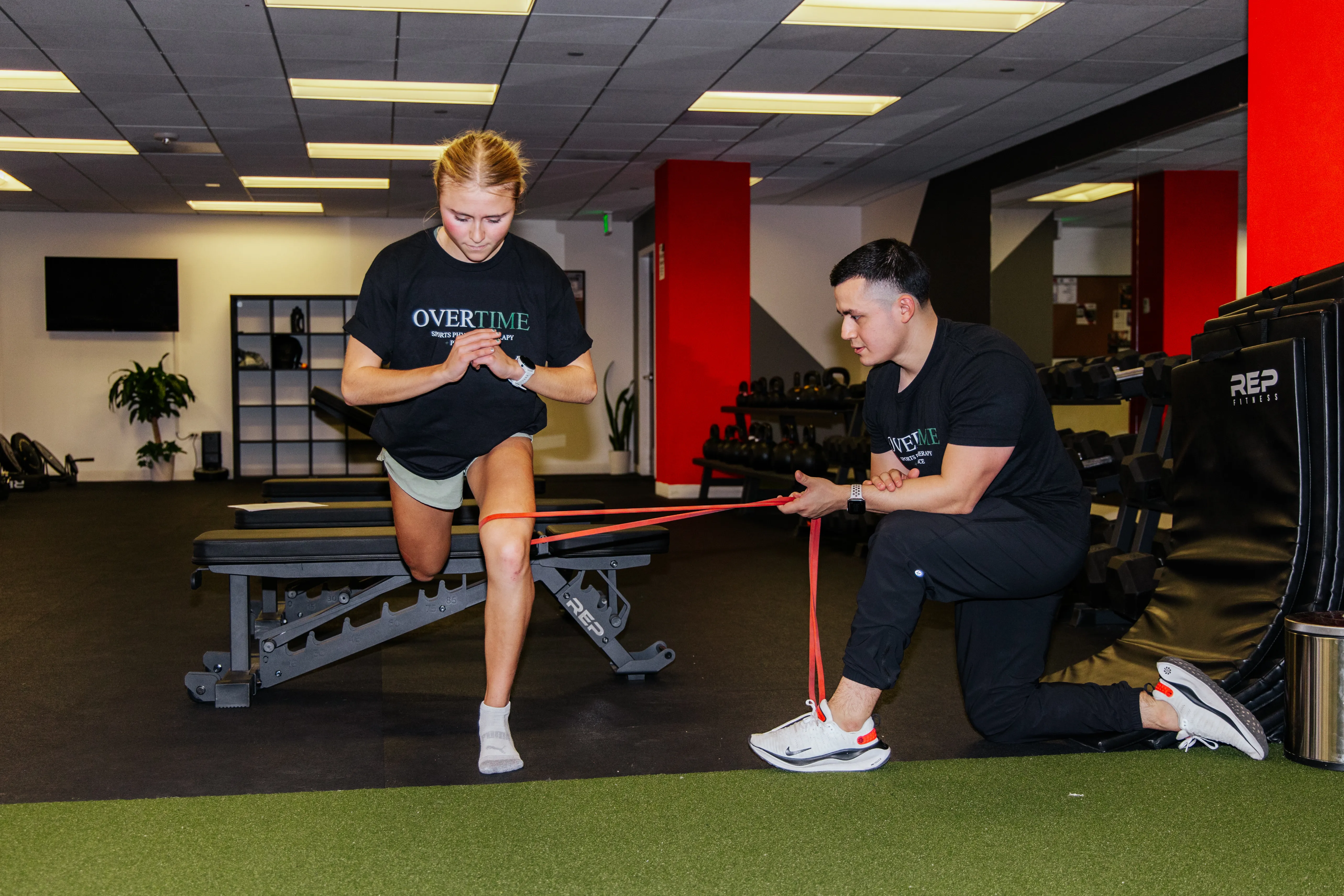 Dr. Benitez works with a young woman to improve lower body strength through physical therapy.
