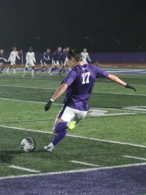 A soccer player about to kick the ball to his teammates.
